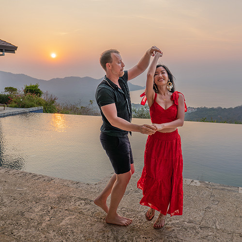 Newly engaged couple dancing together at home