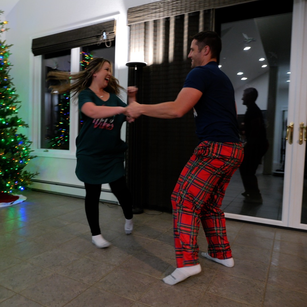 Couple laughing and dancing at home in pajamas